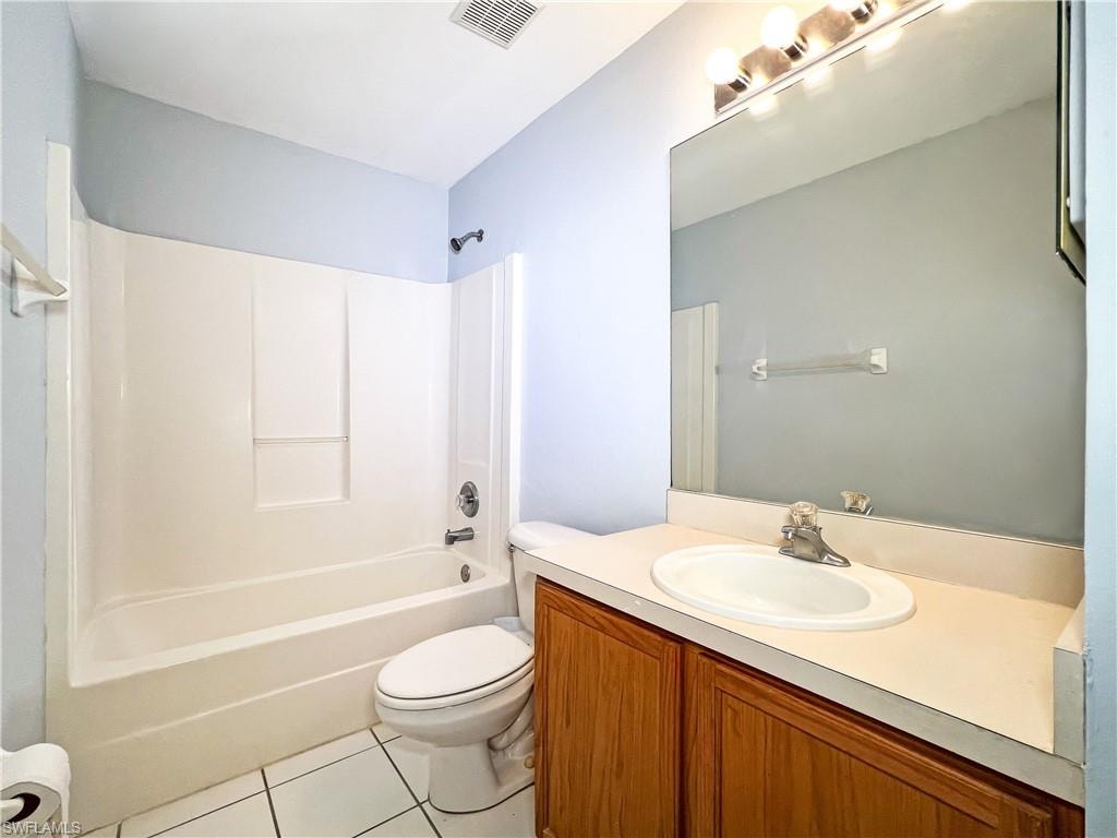 Bathroom featuring vanity, light tile patterned flooring, and  shower combination