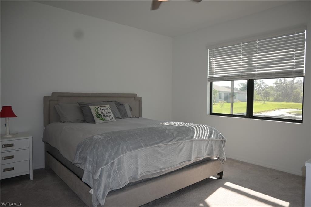 Carpeted bedroom featuring a ceiling fan