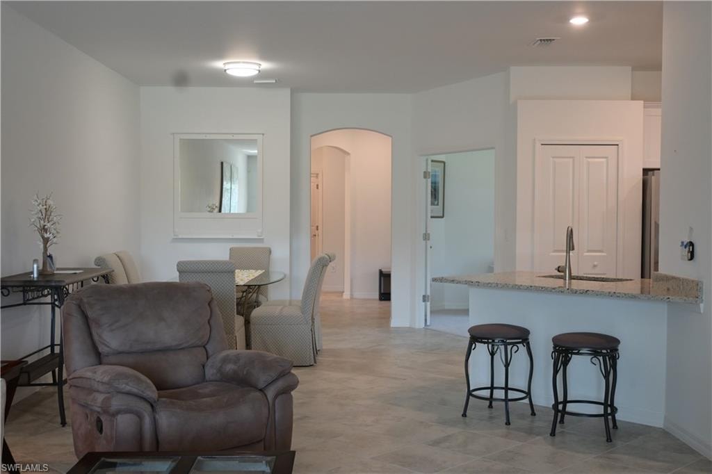 Living room with arched walkways and recessed lighting