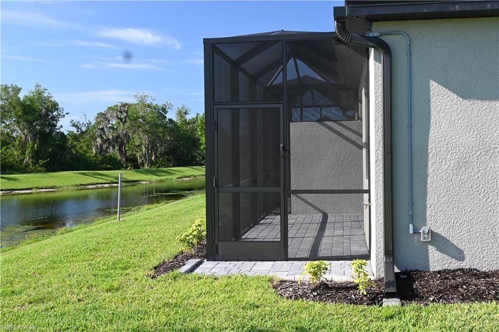 View of outdoor structure with a sunroom and a water view