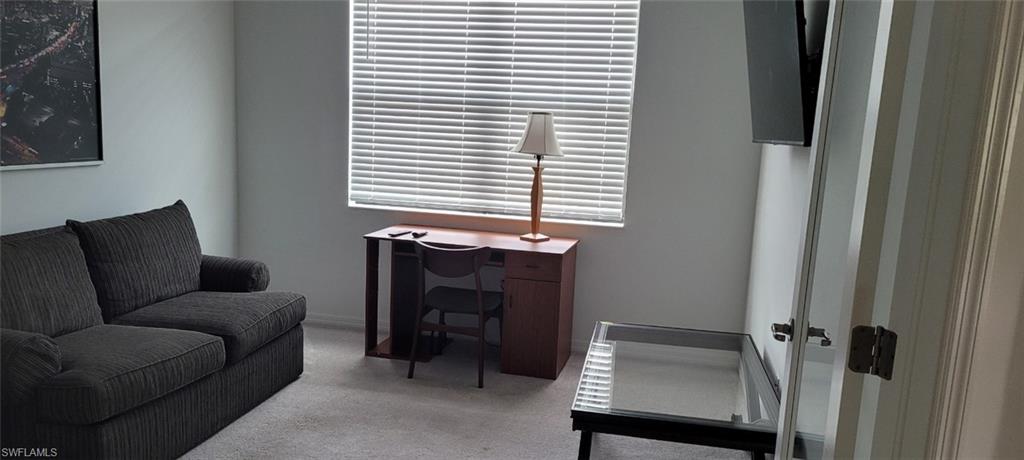 Sitting room featuring carpet flooring and a desk