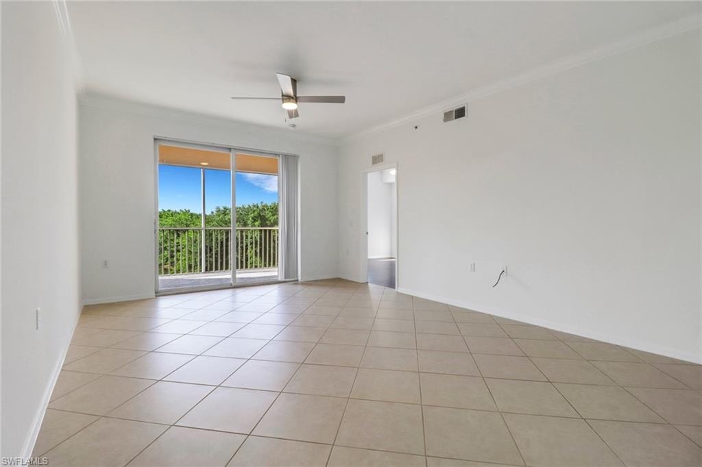Tiled empty room with crown molding and ceiling fan