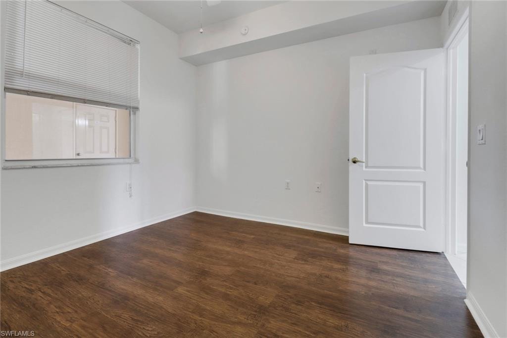 Unfurnished room with dark wood-type flooring