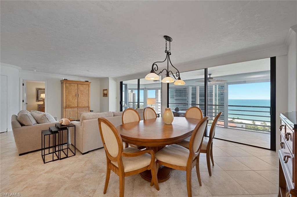 Dining space featuring crown molding, a water view, and light tile patterned floors