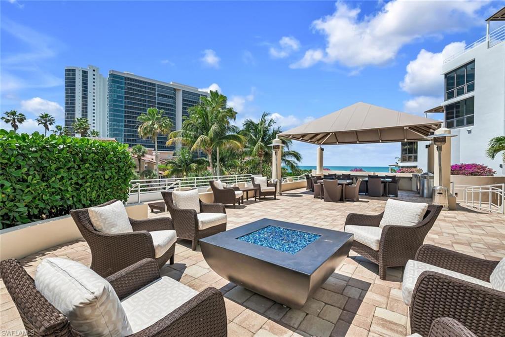 View of patio featuring a fire pit, an outdoor lounge area with bar, and a gazebo