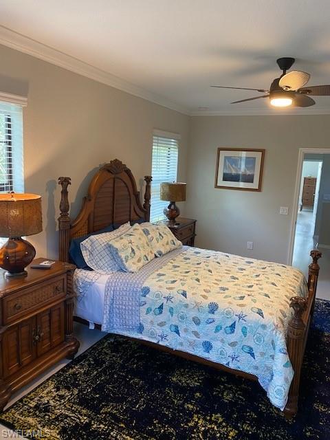 Bedroom featuring multiple windows, crown molding, and ceiling fan