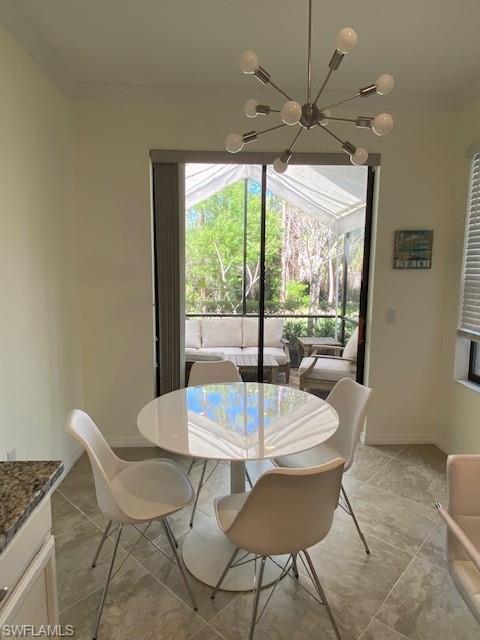 Dining space with an inviting chandelier, tile flooring, and crown molding