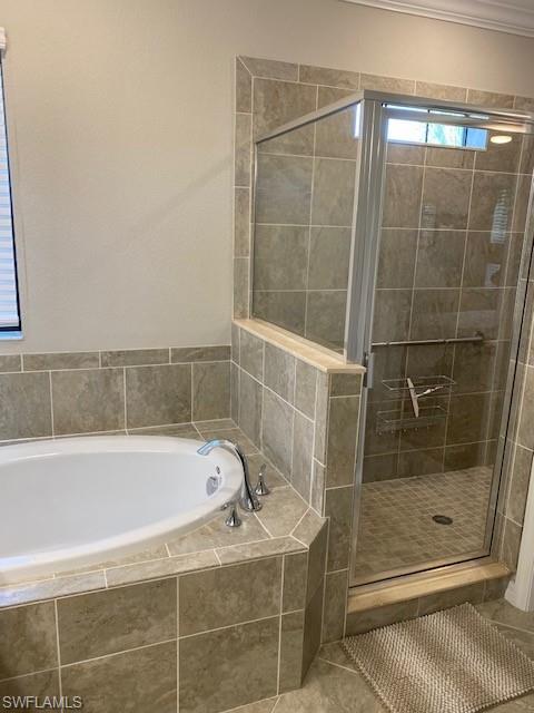 Bathroom with tile flooring, ornamental molding, and plus walk in shower