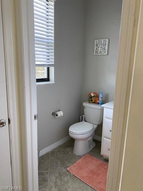 Bathroom with tile flooring, vanity, and toilet