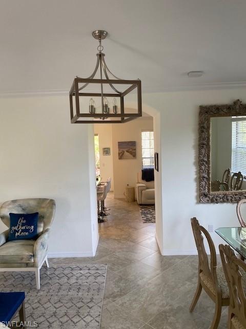 Dining area featuring crown molding, an inviting chandelier, and tile floors