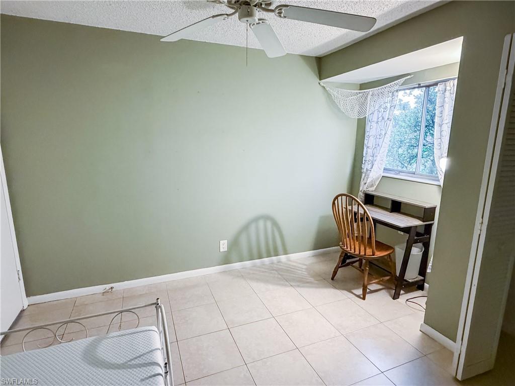 Guest bedroom #2 featuring a ceiling fan, a textured ceiling, and light tile patterned floors
