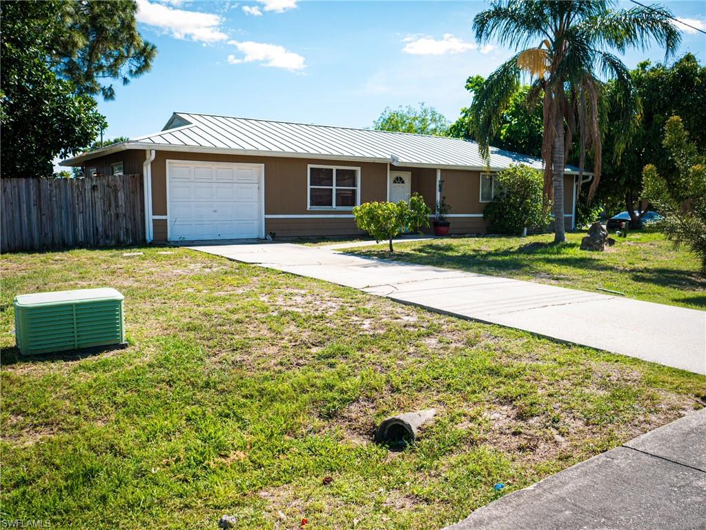 Ranch-style house featuring driveway and a metal roof