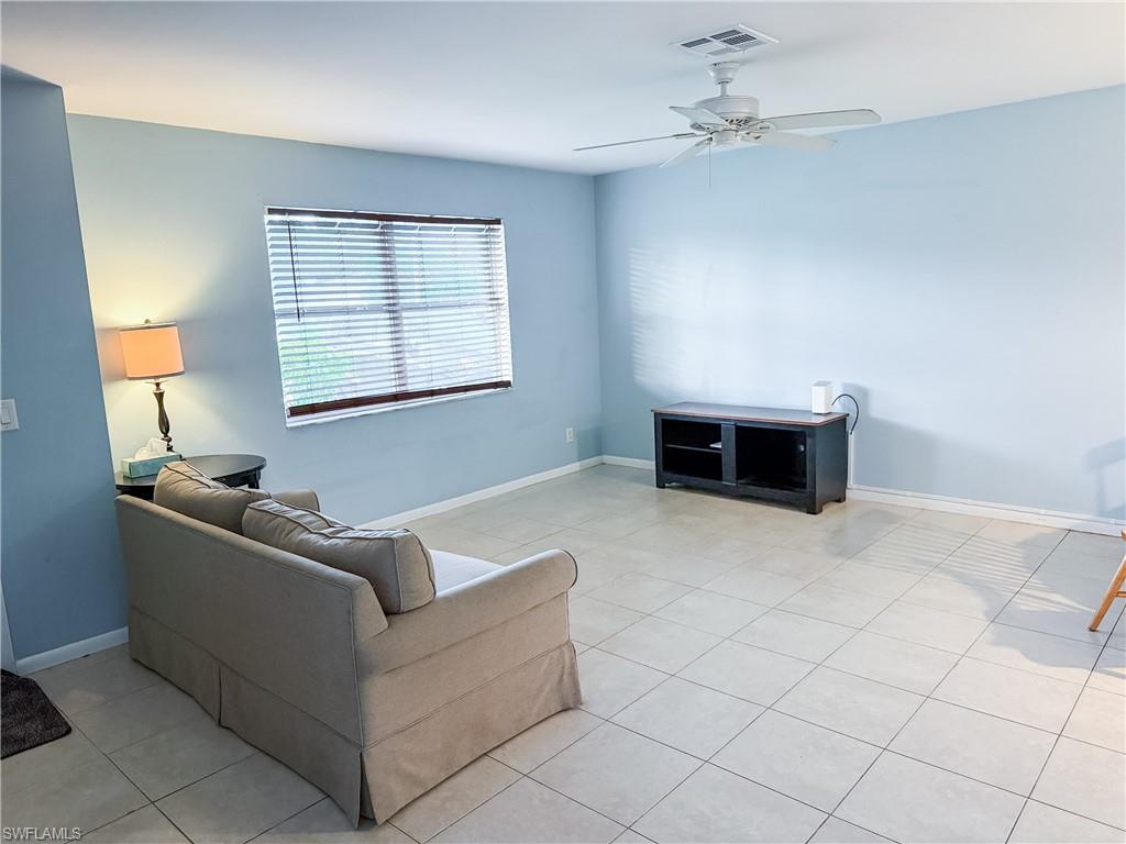 Open living room with ceiling fan and light tile patterned floors