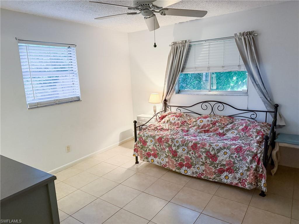 Spacious master bedroom with a textured ceiling and ceiling fan