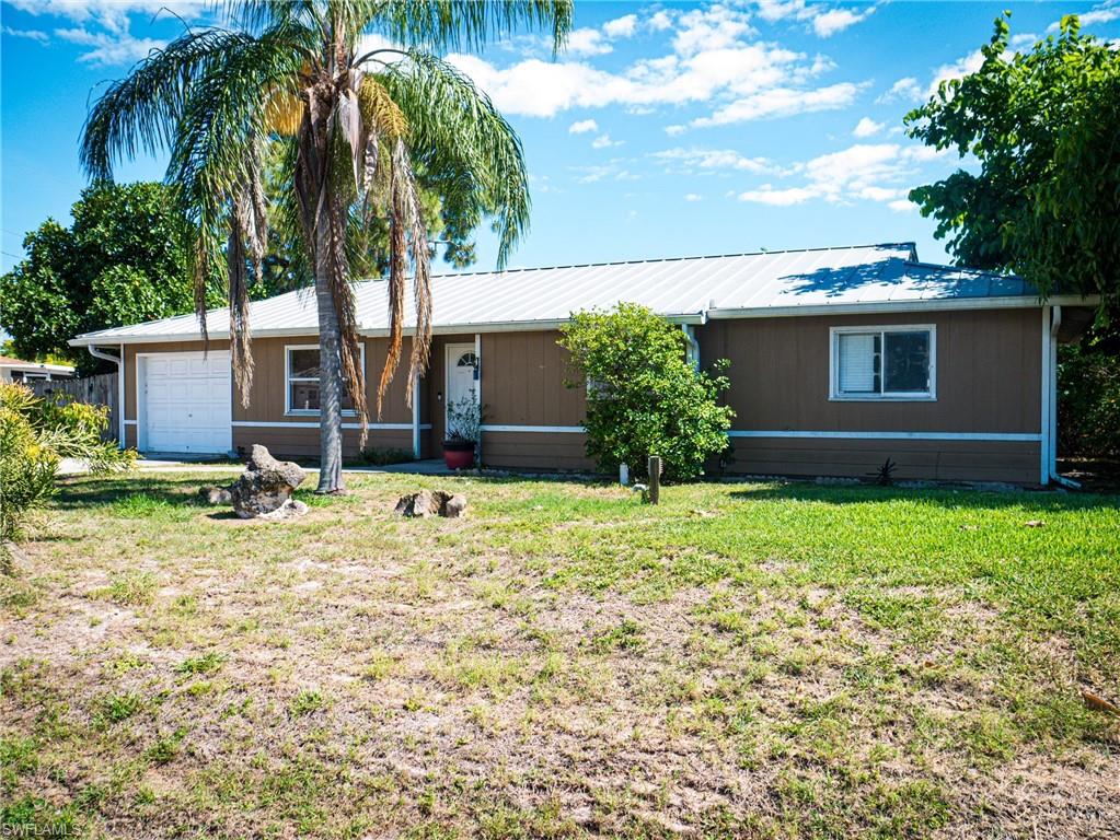 Ranch-style house featuring driveway and a metal roof