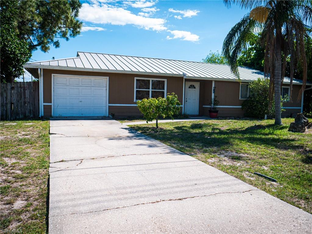 Ranch-style house featuring driveway and a metal roof