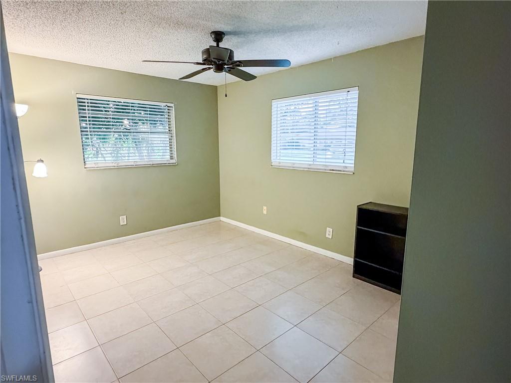 Guest Bedroom #1 featuring a textured ceiling, a ceiling fan, and tile patterned flooring