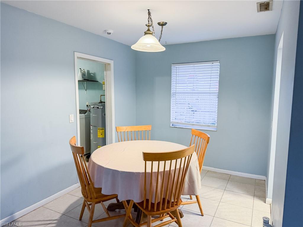 Dining area with light tile patterned flooring and baseboards