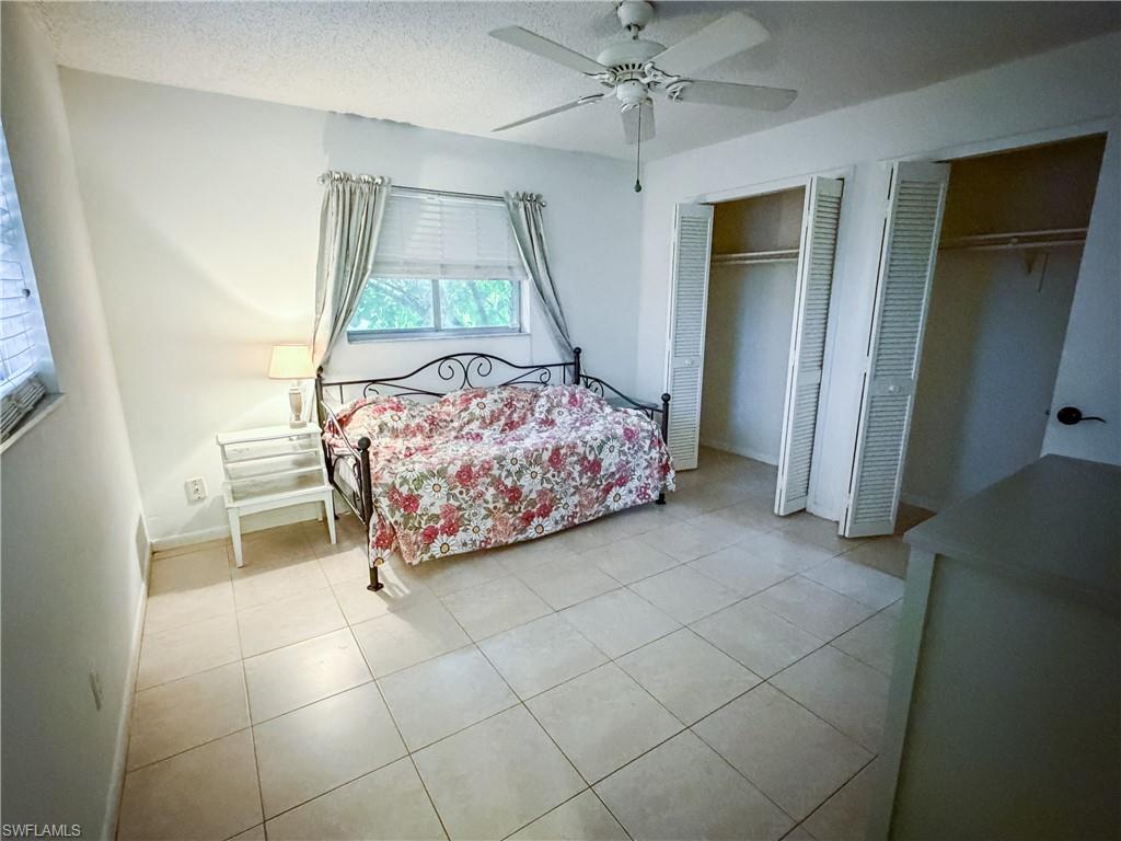Spacious master bedroom with a textured ceiling and ceiling fan