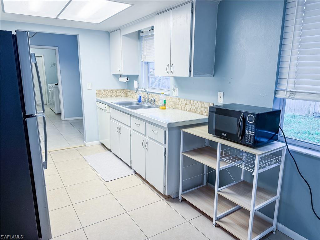 Kitchen featuring light countertops, white cabinets, and updated appliances.