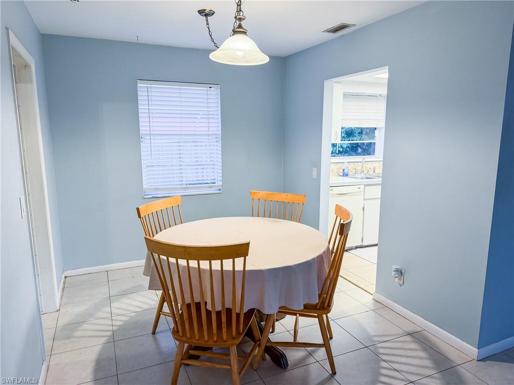 Dining area with light tile patterned flooring and baseboards