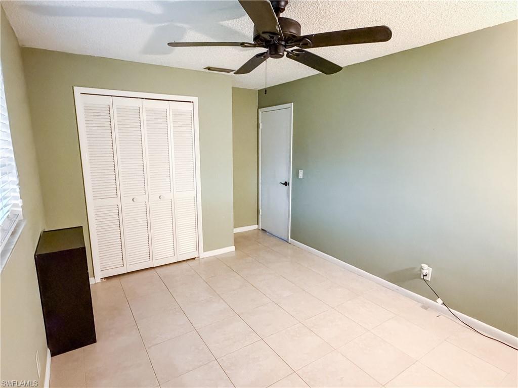 Guest Bedroom #1 featuring a textured ceiling, a ceiling fan, and tile patterned flooring