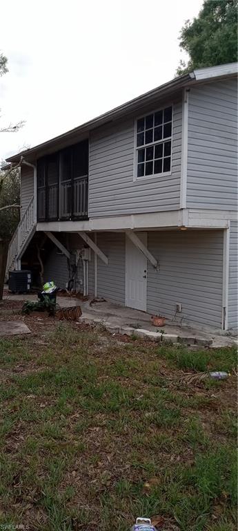 Back of house featuring a sunroom and a wooden deck
