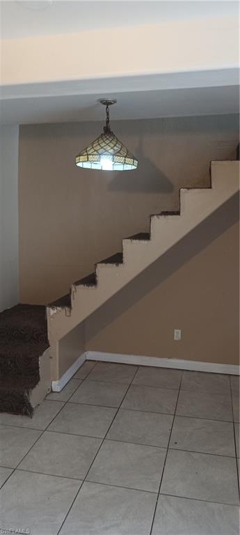 Stairway with carpet patterned floors and baseboards