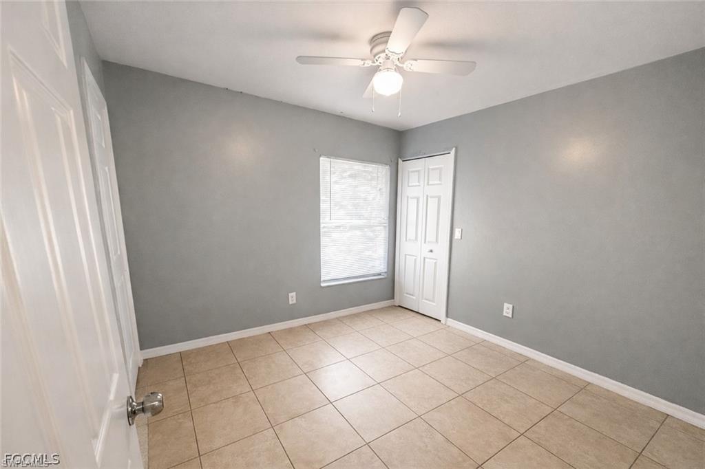 Unfurnished bedroom featuring a ceiling fan, a closet, and light tile patterned flooring