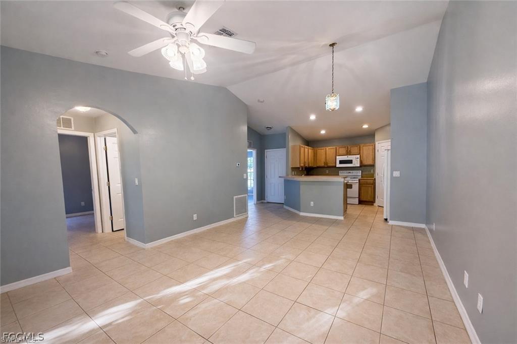 Unfurnished living room with a ceiling fan, light tile patterned flooring, arched walkways, and recessed lighting