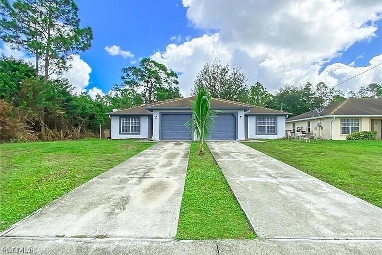 Ranch-style home featuring a front yard, driveway, an attached garage, and stucco siding