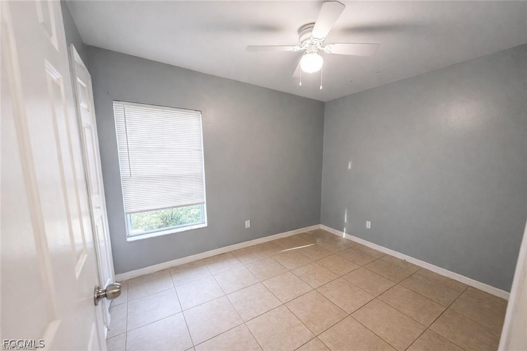 Spare room with ceiling fan and light tile patterned floors