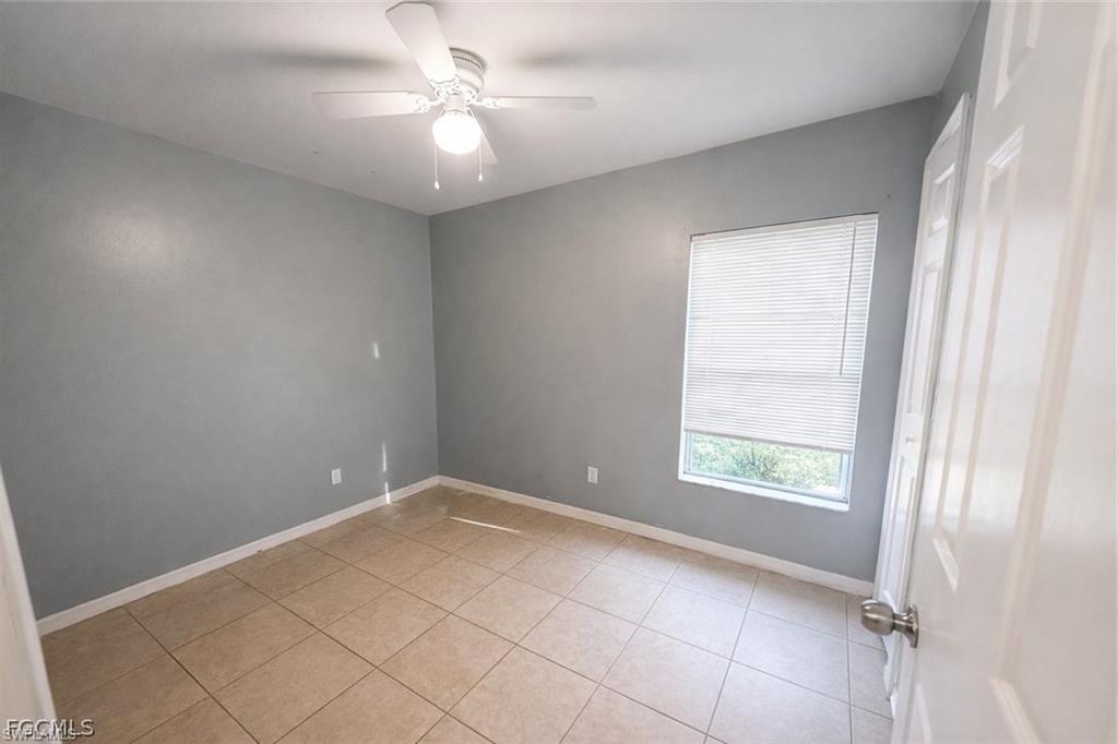 Spare room with a ceiling fan and light tile patterned floors