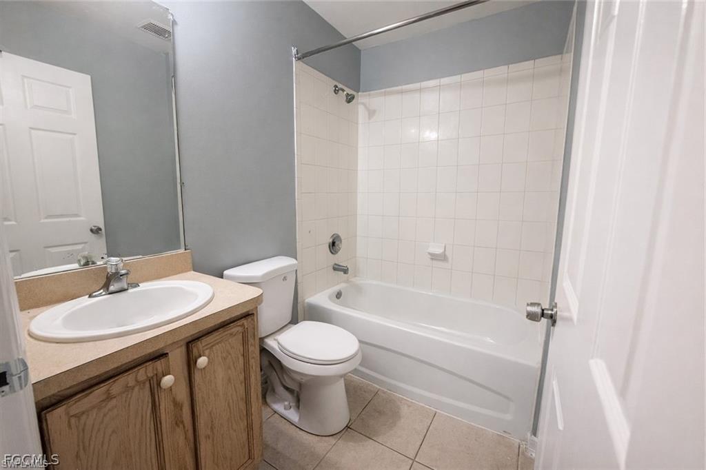 Full bath with vanity, bathtub / shower combination, and light tile patterned flooring
