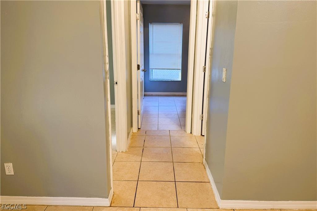Corridor featuring baseboards and light tile patterned floors