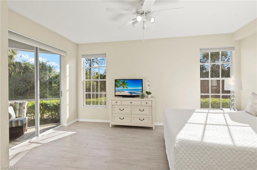 Bedroom with baseboards, access to outside, a ceiling fan, and light wood-style flooring
