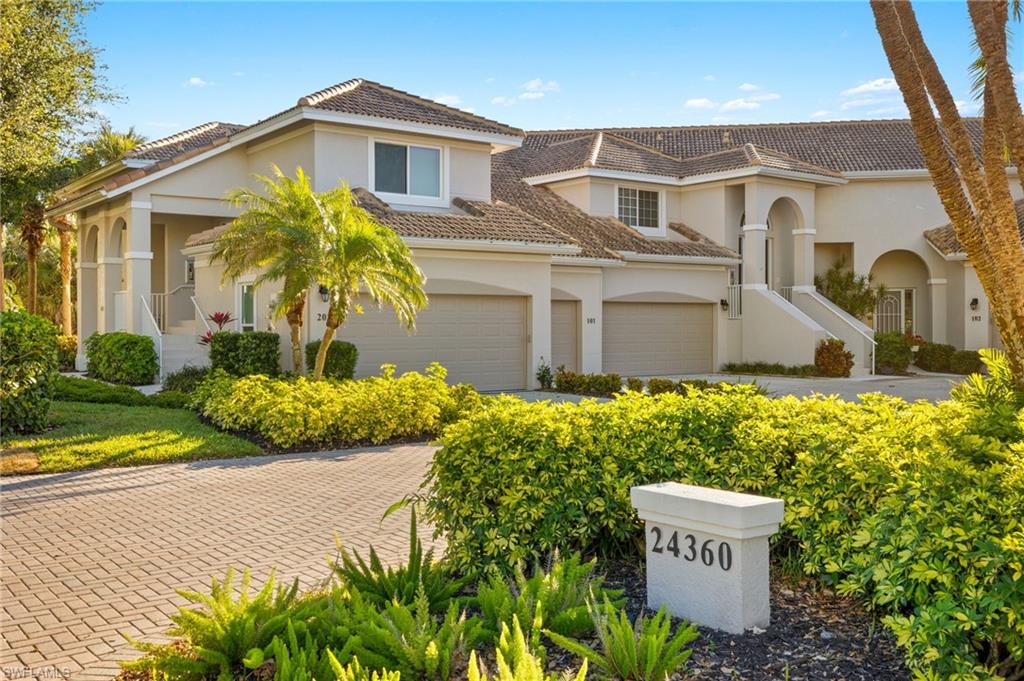 View of front of home featuring stucco siding, a tile roof, driveway, and an attached garage