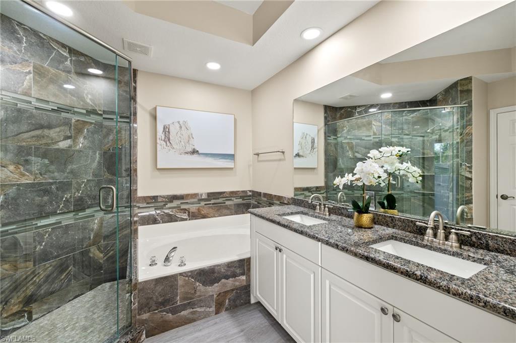 Full bath with a garden tub, a shower stall, double vanity, and recessed lighting