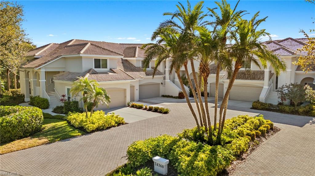 Mediterranean / spanish-style home with driveway, a tiled roof, an attached garage, stucco siding, and stairway