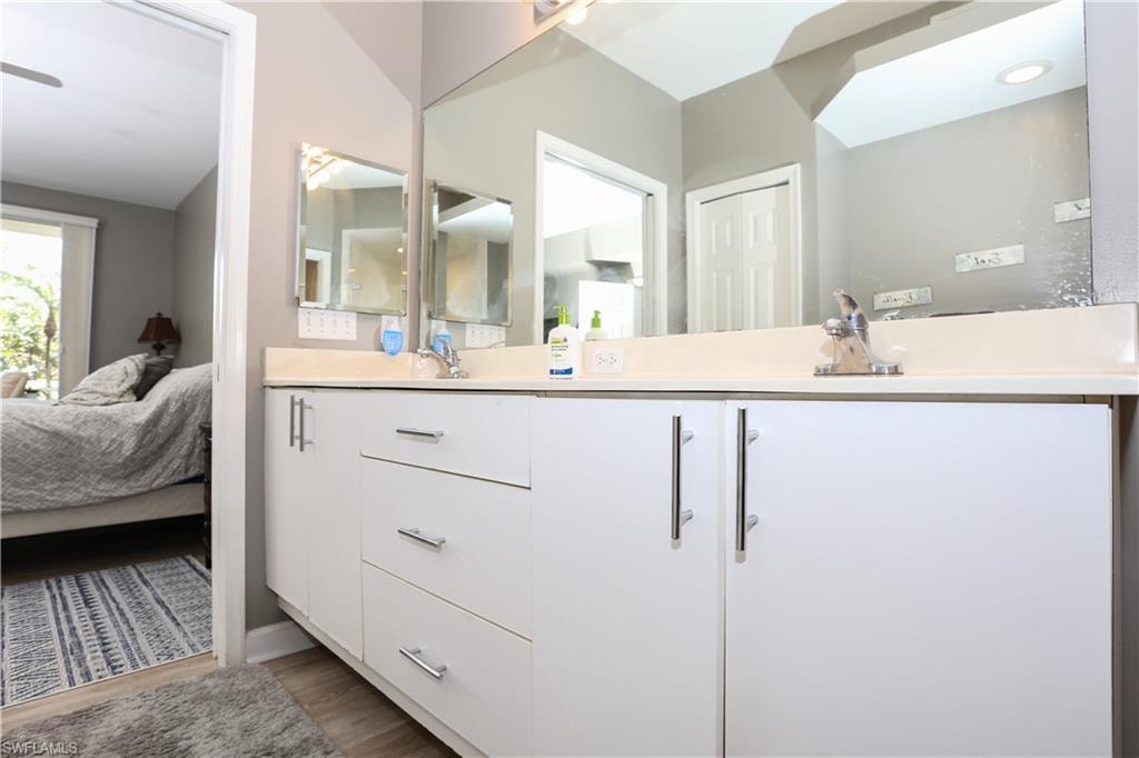 Ensuite bathroom with double vanity and dark wood finished floors