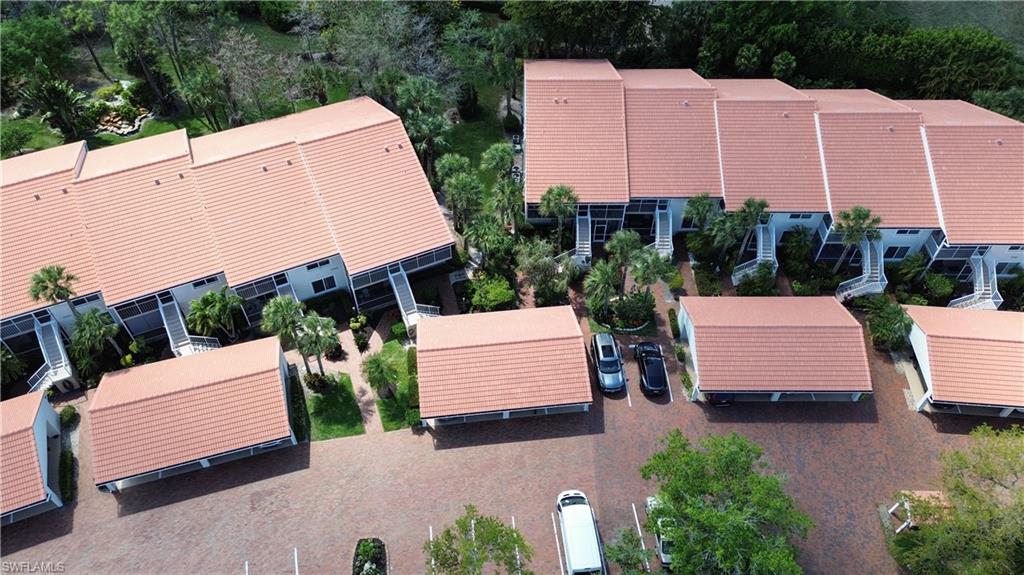 Drone / aerial view of apartment complex / building and a tree filled landscape