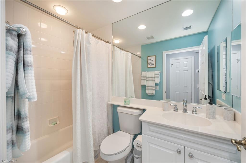 Bathroom with vanity, shower / bath combination with curtain, and recessed lighting