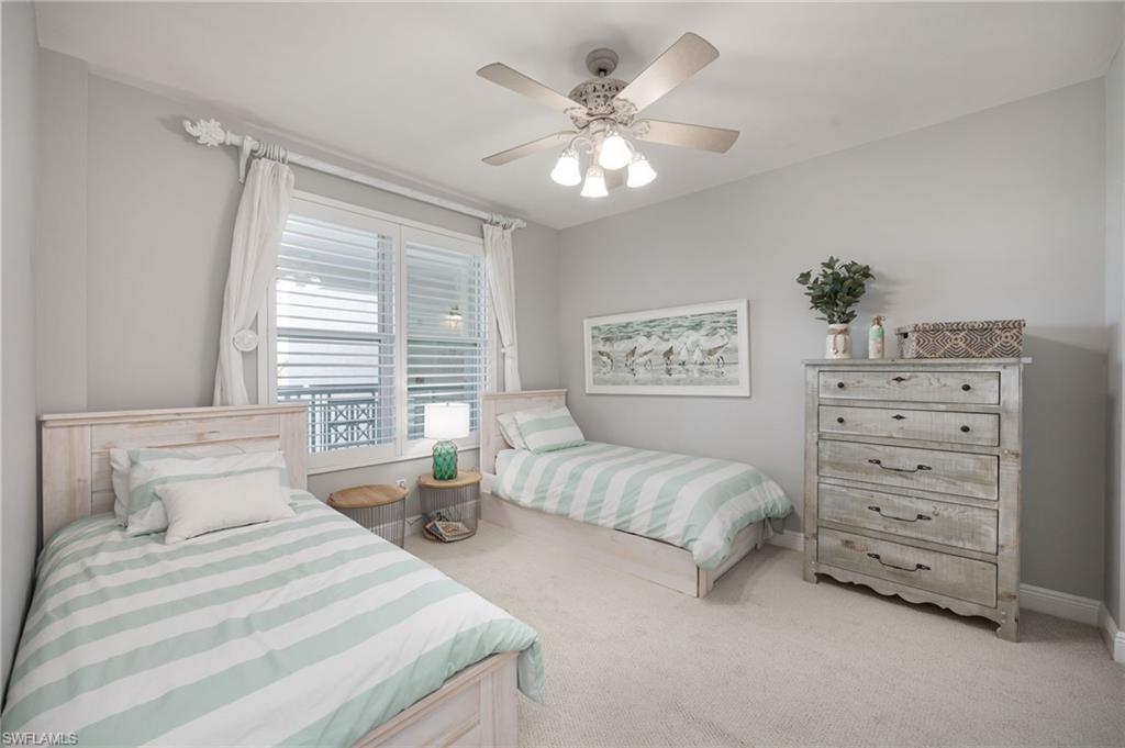 Bedroom with light colored carpet and a ceiling fan