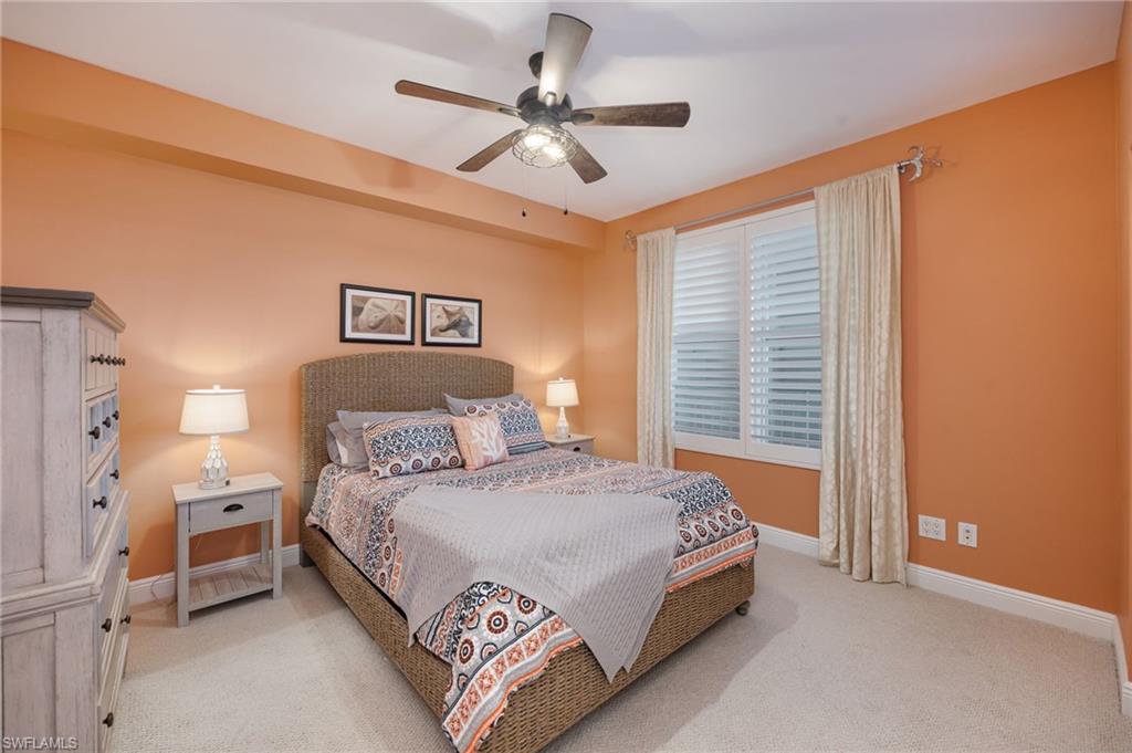 Bedroom with a ceiling fan and light colored carpet