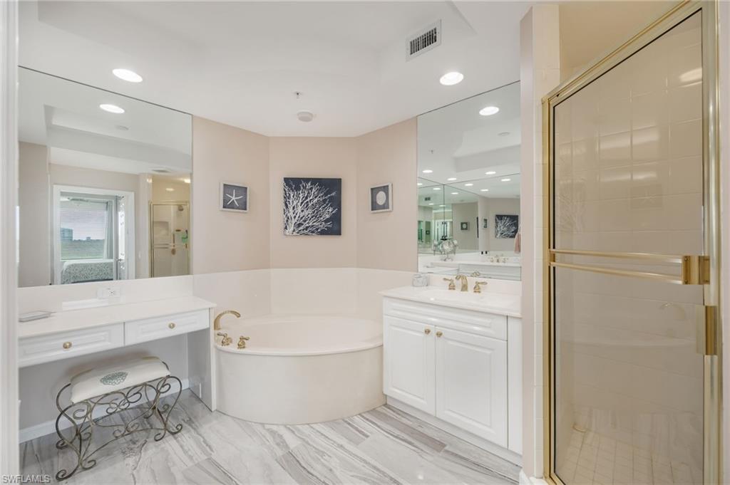 Bathroom with a shower stall, vanity, recessed lighting, and a bath