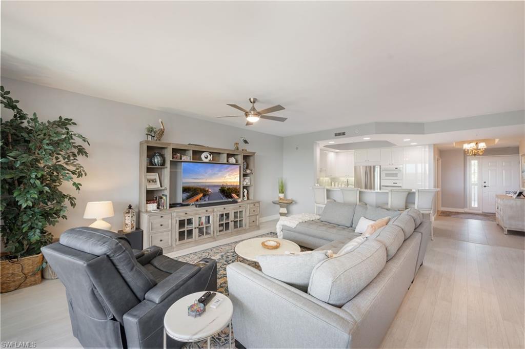 Living area with ceiling fan, hanging lights, and light wood finished floors