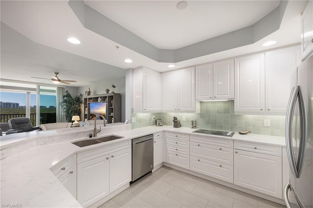 Kitchen featuring white cabinetry, light stone counters, stainless steel appliances, recessed lighting, and a ceiling fan
