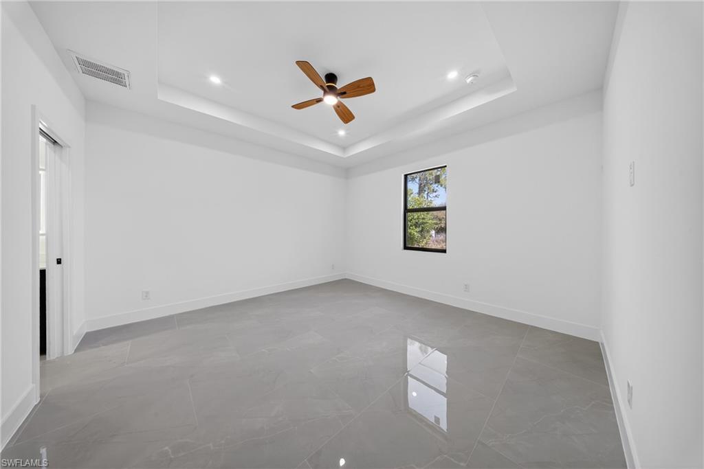 Unfurnished room featuring ceiling fan and baseboards