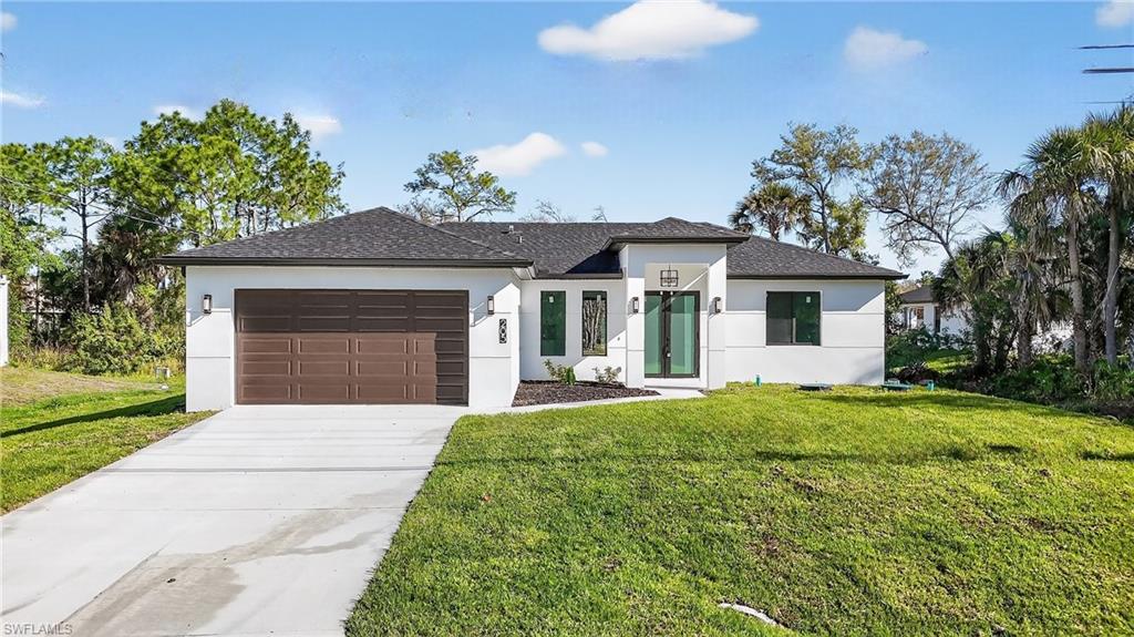 View of front of house featuring a front lawn and stucco siding