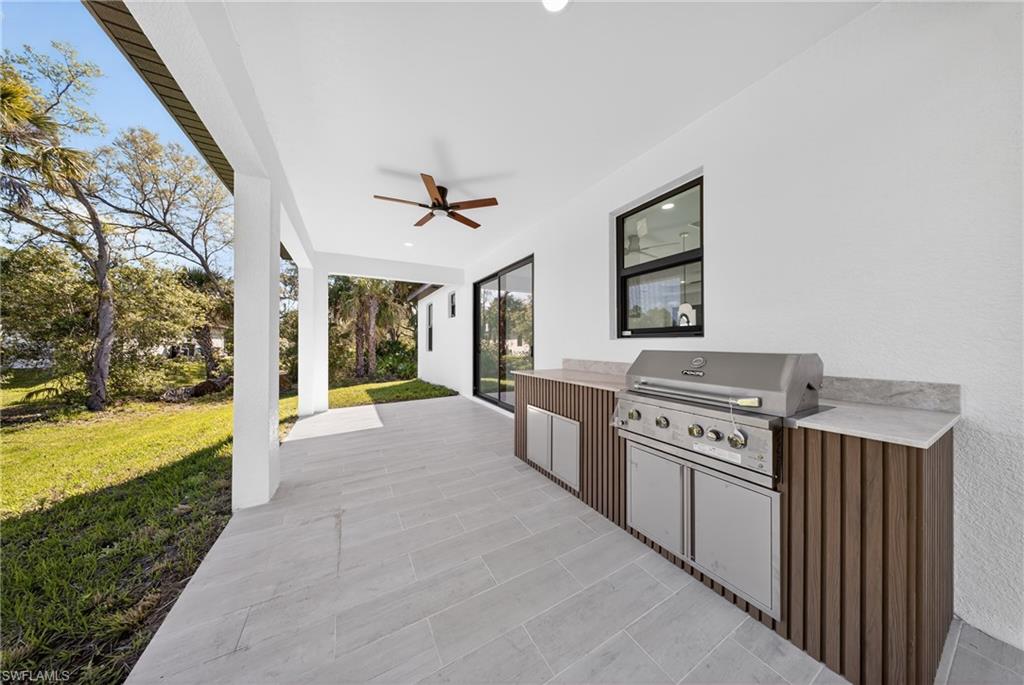 View of patio with exterior kitchen and a ceiling fan